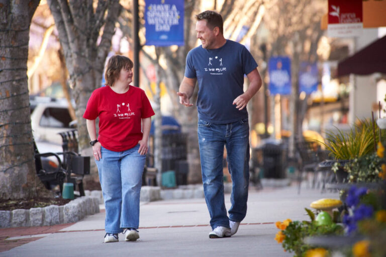 Julie and Derrick walking down a street.