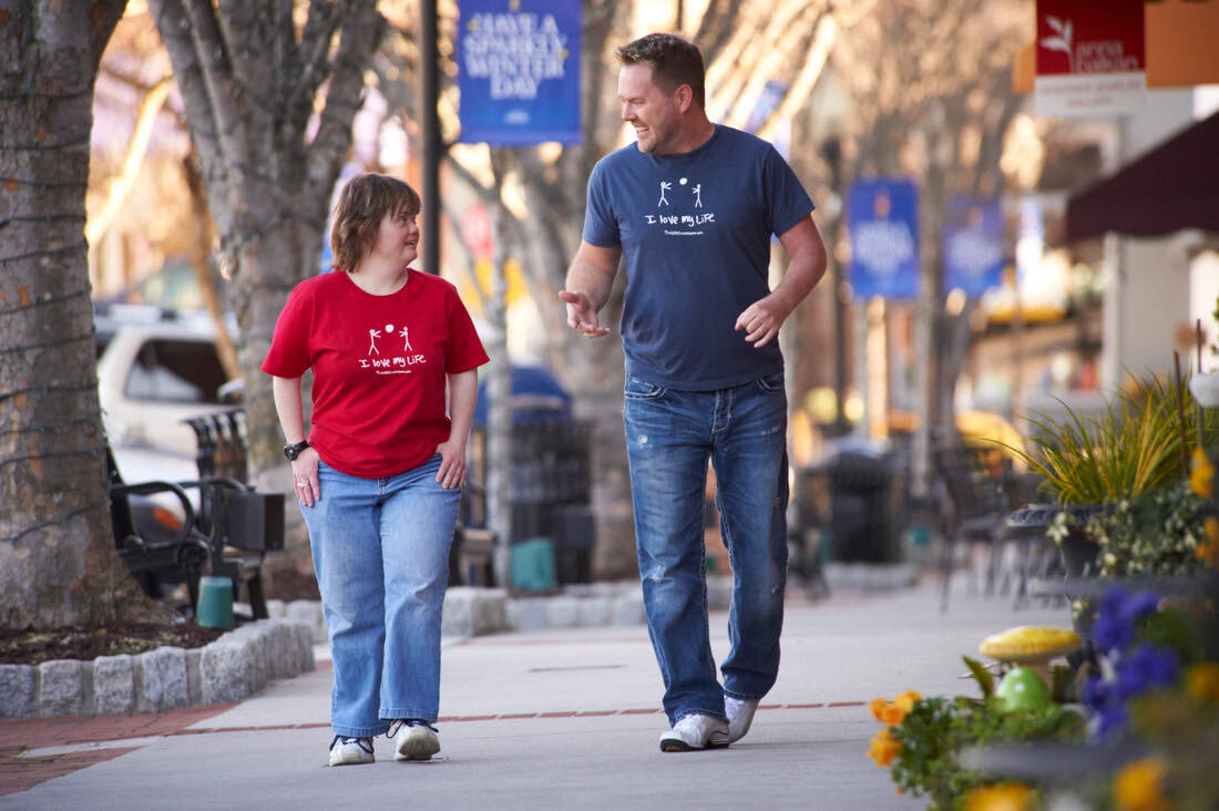 Julie and Derrick walking down a street.